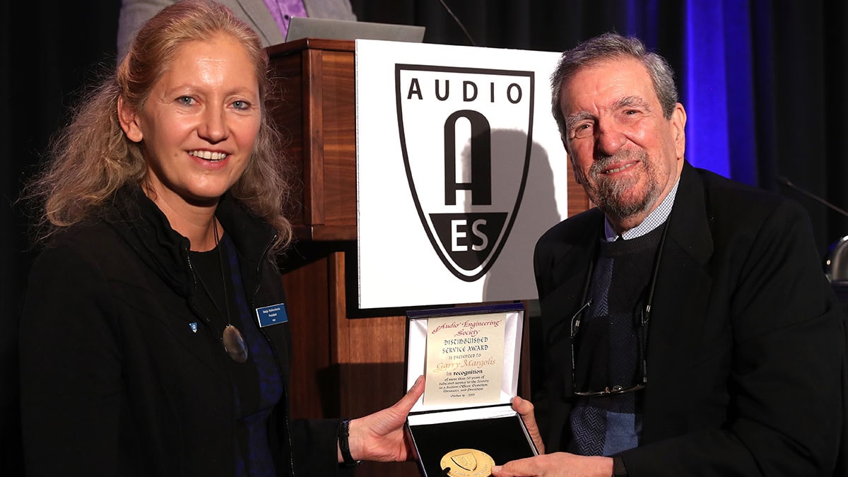 Garry Margolis, AES Past President, receives the AES Distinguished Service Medal in 2019 from then President Nadia Wallaszkovits