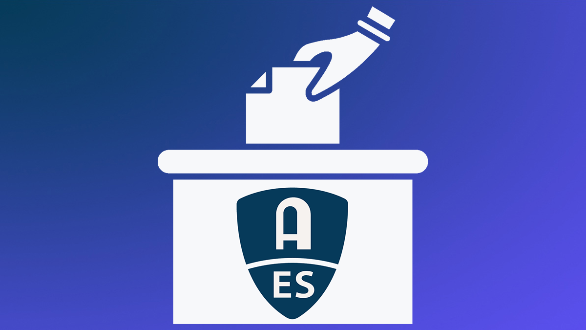 Hand placing ballot in voting box with AES logo on box