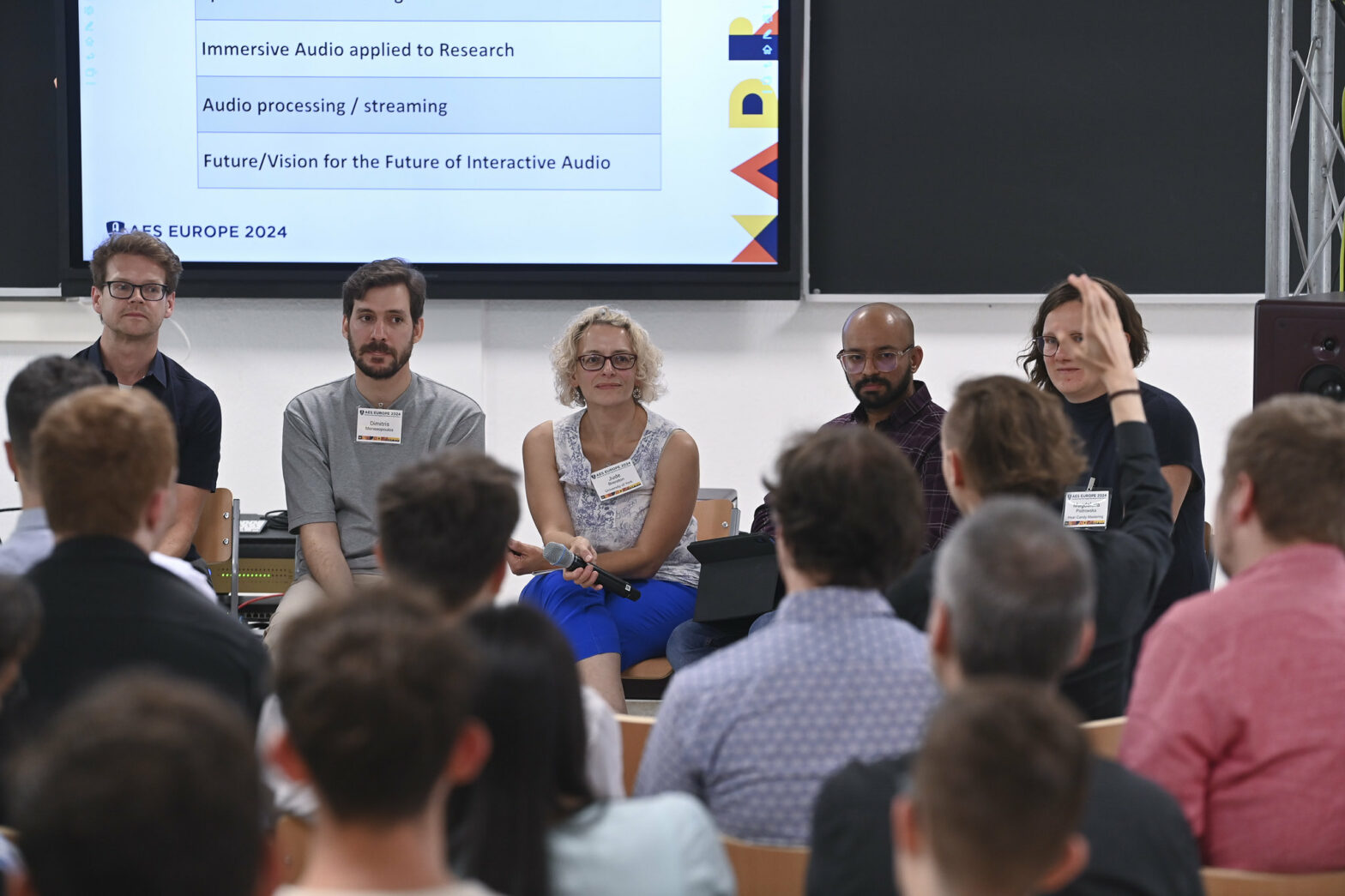 Attendees listen to panel of speakers at AES Europe 2024.